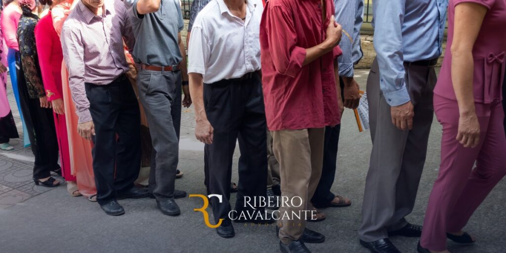 Pessoas em fila de espera na rua, várias idades e roupas coloridas. Logotipo Ribeiro Cavalcante Advocacia.