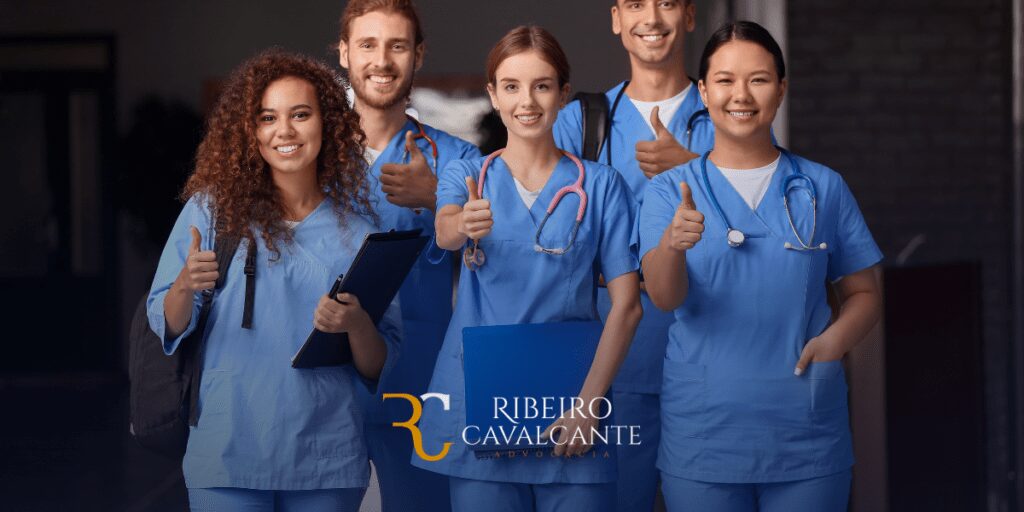 Grupo de enfermeiros sorridentes com jalecos azuis mostrando sinal de positivo. Logo Ribeiro Cavalcante Advocacia marca a imagem.