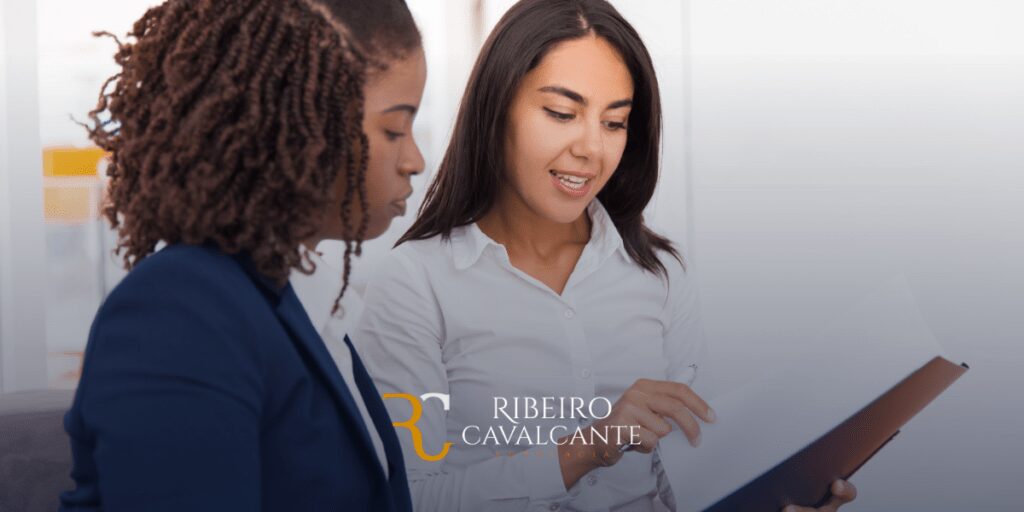 Duas mulheres discutindo um documento no escritório da Ribeiro Cavalcante Advocacia.
