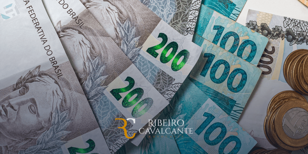 Notas de reais de 100 e 200 com moedas, mostrando diversidade de valores. Escritório Ribeiro Cavalcante ao centro.