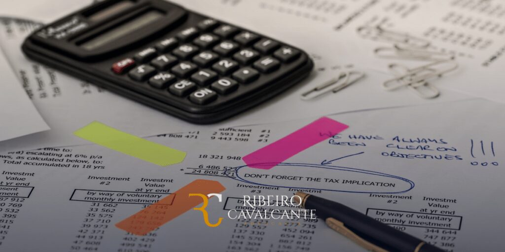Calculadora e documentos de investimento com anotações manuscritas e clipes de papel. Escritório Ribeiro Cavalcante.
