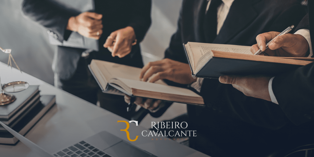 Advogados discutindo documentos jurídicos em um escritório, representando o escritório de advocacia Ribeiro Cavalcante.