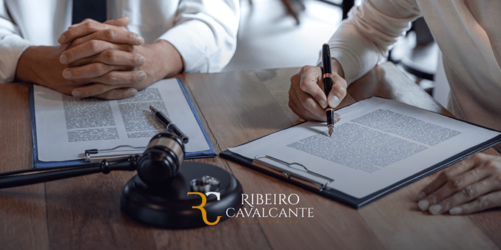 Advogados assinando documentos com martelo judicial ao lado. Logo Ribeiro Cavalcante Advocacia visível na imagem.