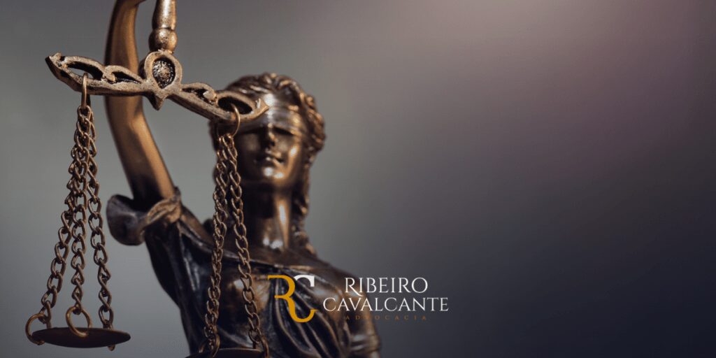 Estátua da Justiça com o logotipo da Ribeiro Cavalcante Advocacia ao fundo, representando serviços jurídicos profissionais.