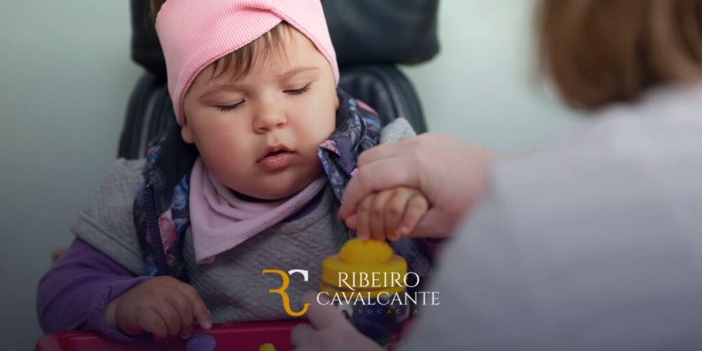 Bebê de olhos fechados segurando mão de adulto com logo da Ribeiro Cavalcante Advocacia, especialista em Direito Previdenciário.