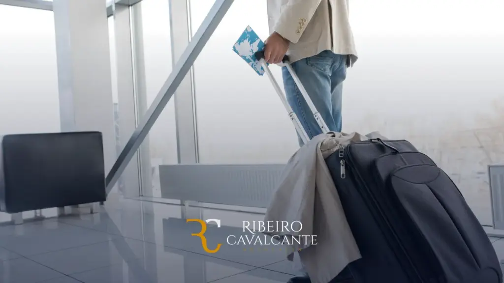 Pessoa segurando passaporte e mala em aeroporto.