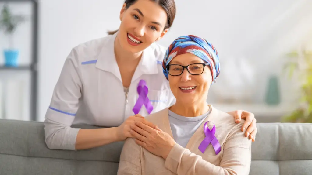 Enfermeira e paciente com laço roxo sorrindo