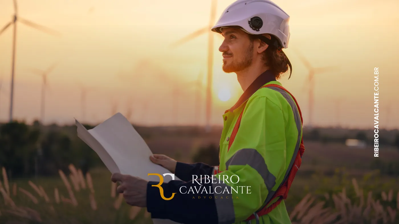 Engenheiro com capacete olhando torres eólicas ao pôr do sol