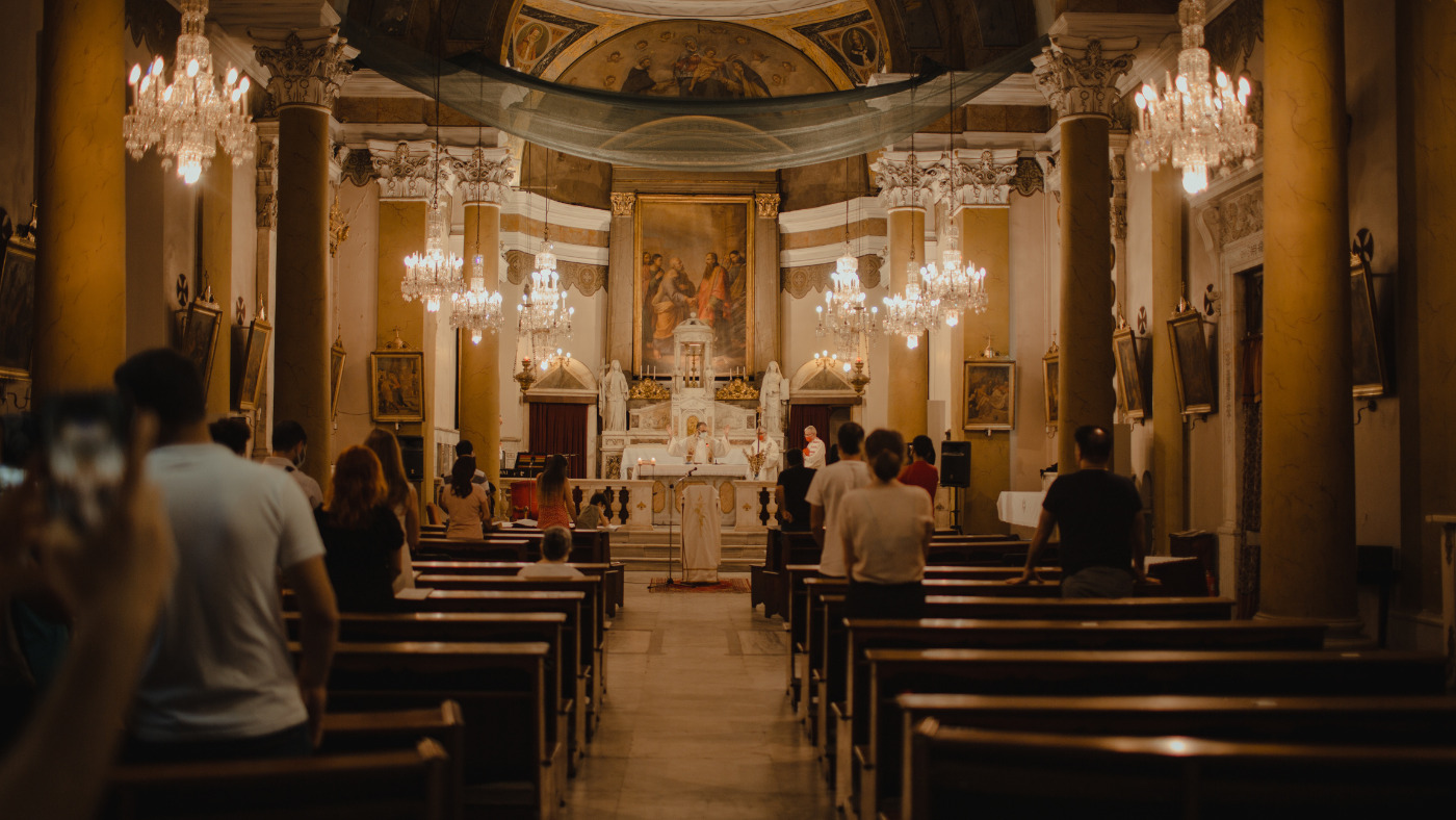 Interior de uma igreja com fiéis em adoração.