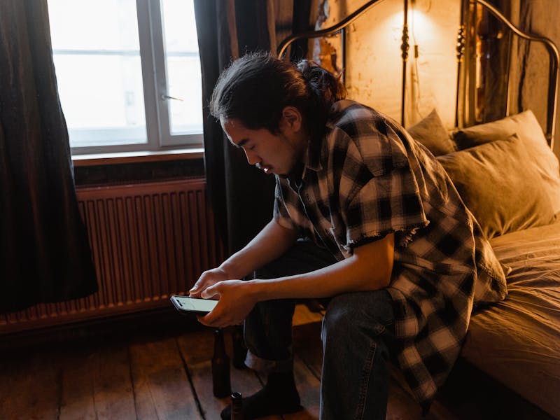 Pessoa preocupada olhando o celular, representando o impacto das apostas online