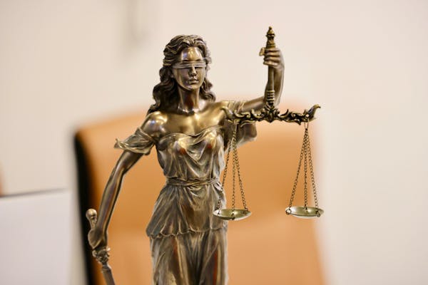 Estátua da Justiça segurando balança, simbolizando a base legal para recuperação de valores