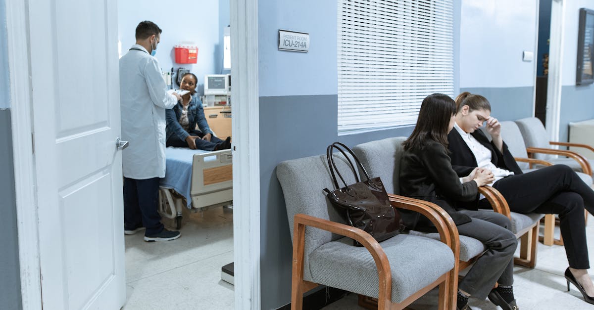 Carencia de plano de saude 72165 1771758123 Pessoas sentadas em sala de espera de hospital enquanto médico atende paciente ao fundo em um quarto. — foto: rdne stock project