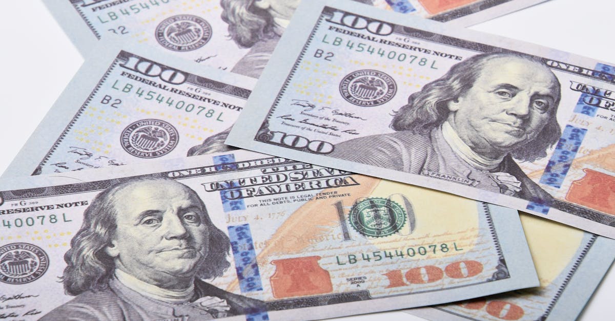 Fintechs pix e contas digitais o novo centro da lavagem de dinheiro 72363 1771806460 Diversas notas de cem dólares americanos espalhadas sobre uma superfície branca. — foto: adrian vieriu
