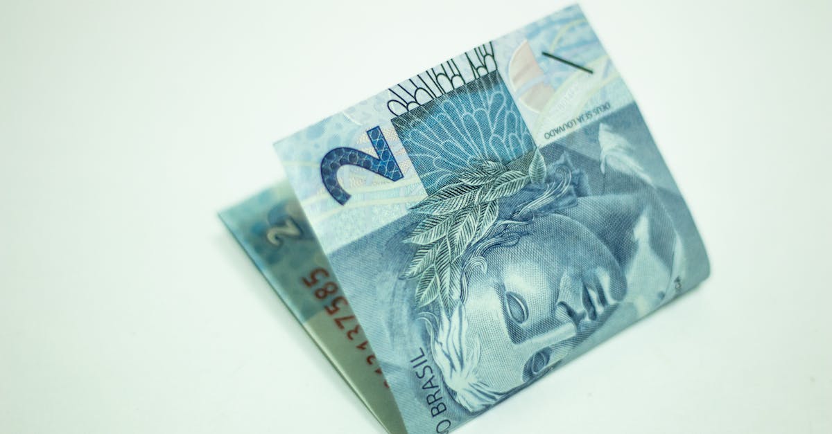 Uma cédula de dois reais brasileiros dobrada sobre um fundo branco liso. — Foto: Daniel Dan