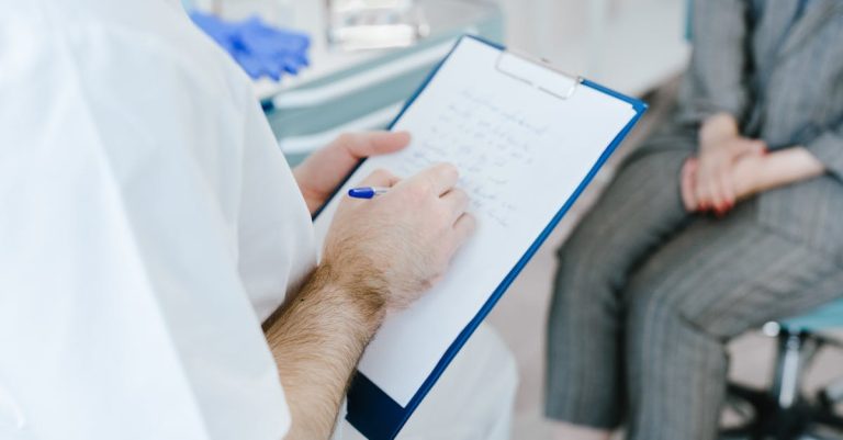 Médico de jaleco branco escrevendo em uma prancheta durante consulta com paciente em consultório. — Foto: SHVETS production