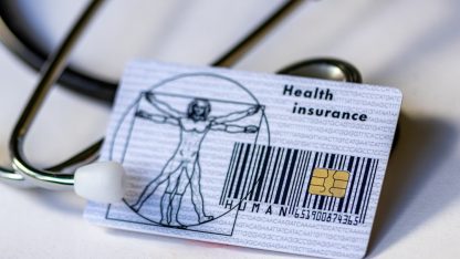 Cartão de plano de saúde com chip e código de barras posicionado sobre um estetoscópio médico. — Foto: Marek Studzinski