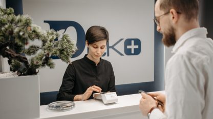 Customer makes a cashless payment at a clinic reception using wireless technology. — Foto: Pavel Danilyuk