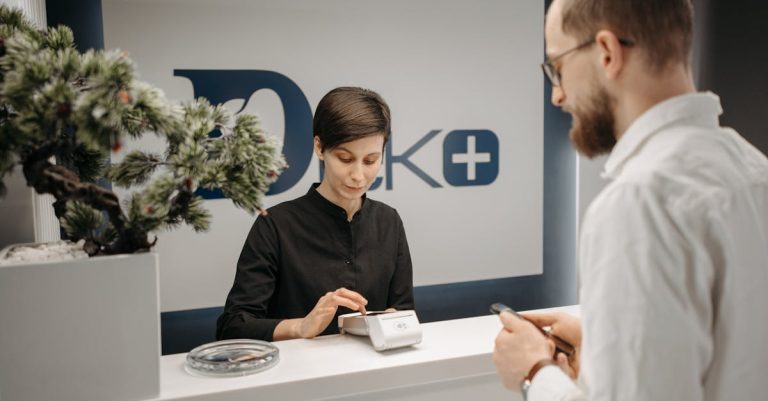 Customer makes a cashless payment at a clinic reception using wireless technology. — Foto: Pavel Danilyuk