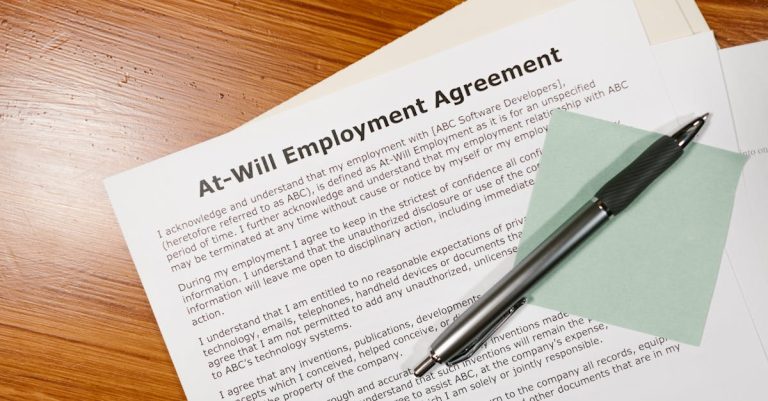 Contrato de trabalho sobre mesa de madeira com uma caneta e bloco de notas adesivo. — Foto: RDNE Stock project