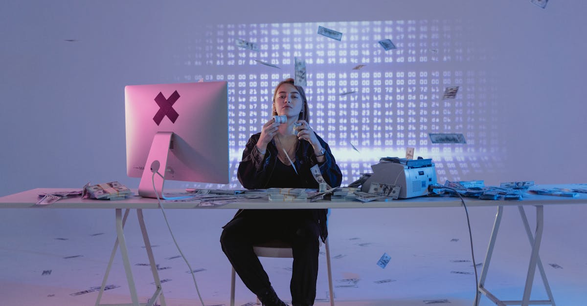 Mulher sentada em mesa com computador, manuseando diversas notas de dinheiro que caem ao seu redor em ambiente moderno. — foto: tima miroshnichenko