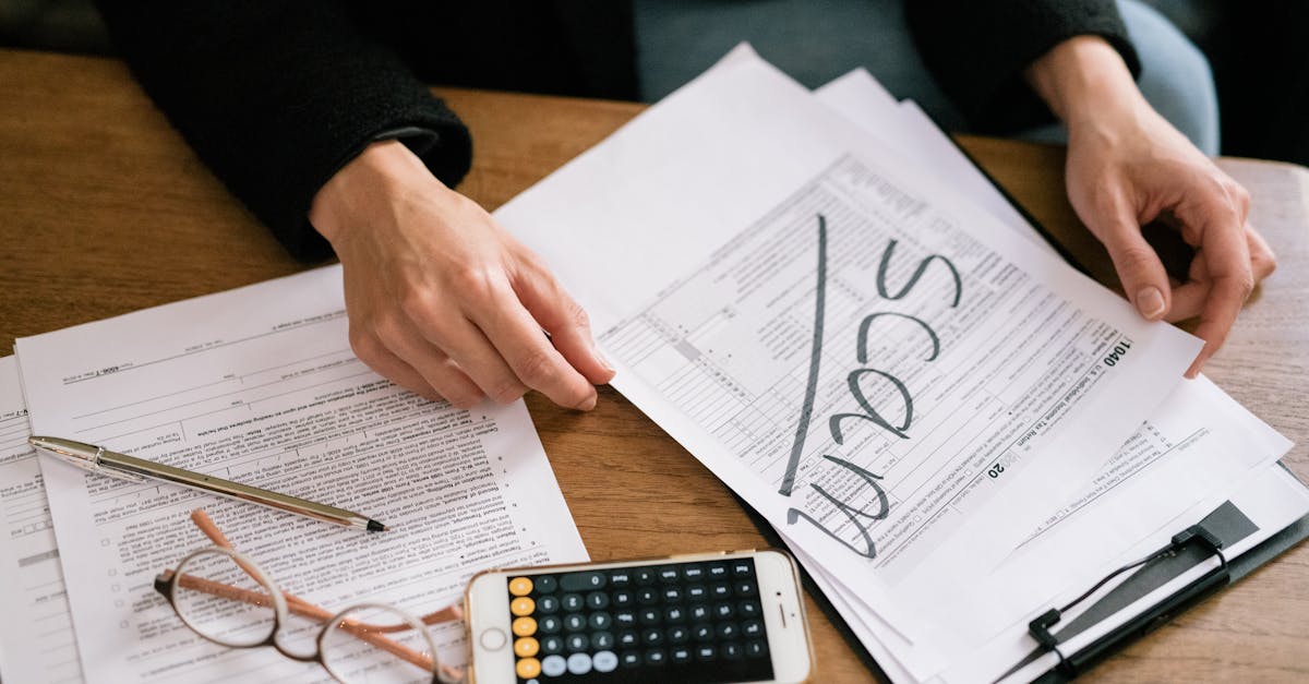 Mãos de uma pessoa manuseando documentos sobre uma mesa com a palavra SCAM escrita em destaque. — Foto: Leeloo The First