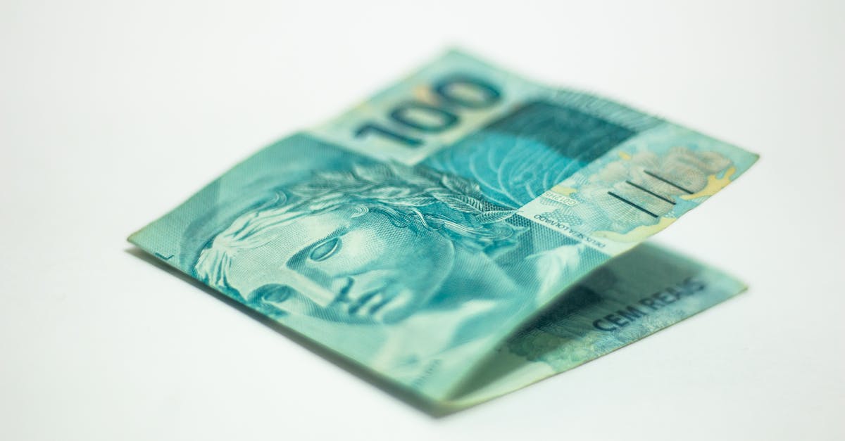 Uma cédula de cem reais dobrada sobre uma superfície branca com foco no rosto da Efígie da República. — Foto: Daniel Dan