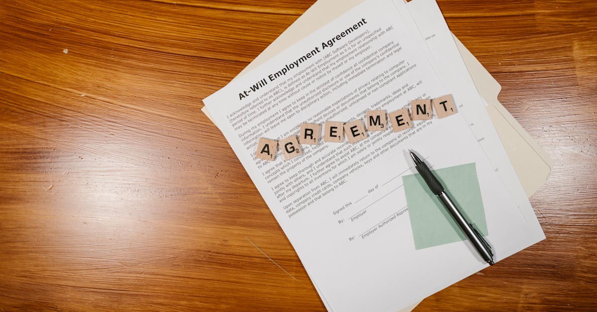 Contrato de trabalho sobre mesa de madeira com caneta e peças de madeira formando a palavra agreement. — Foto: RDNE Stock project