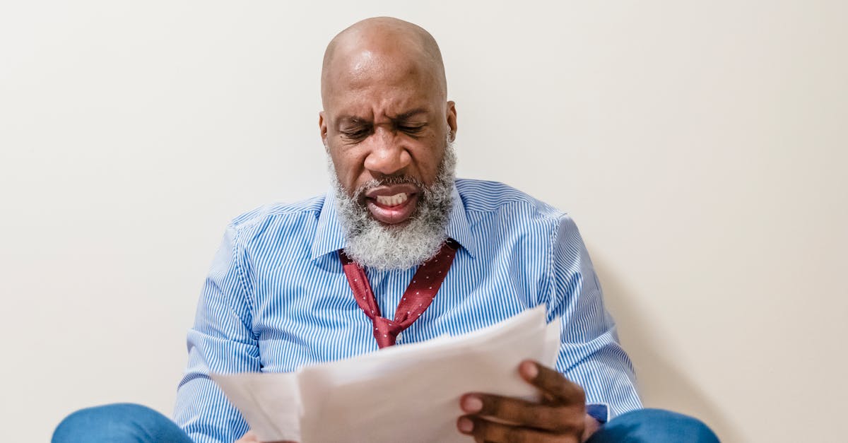 Homem idoso com expressão de frustração e preocupação segurando papéis e documentos oficiais. — Foto: Nicola Barts
