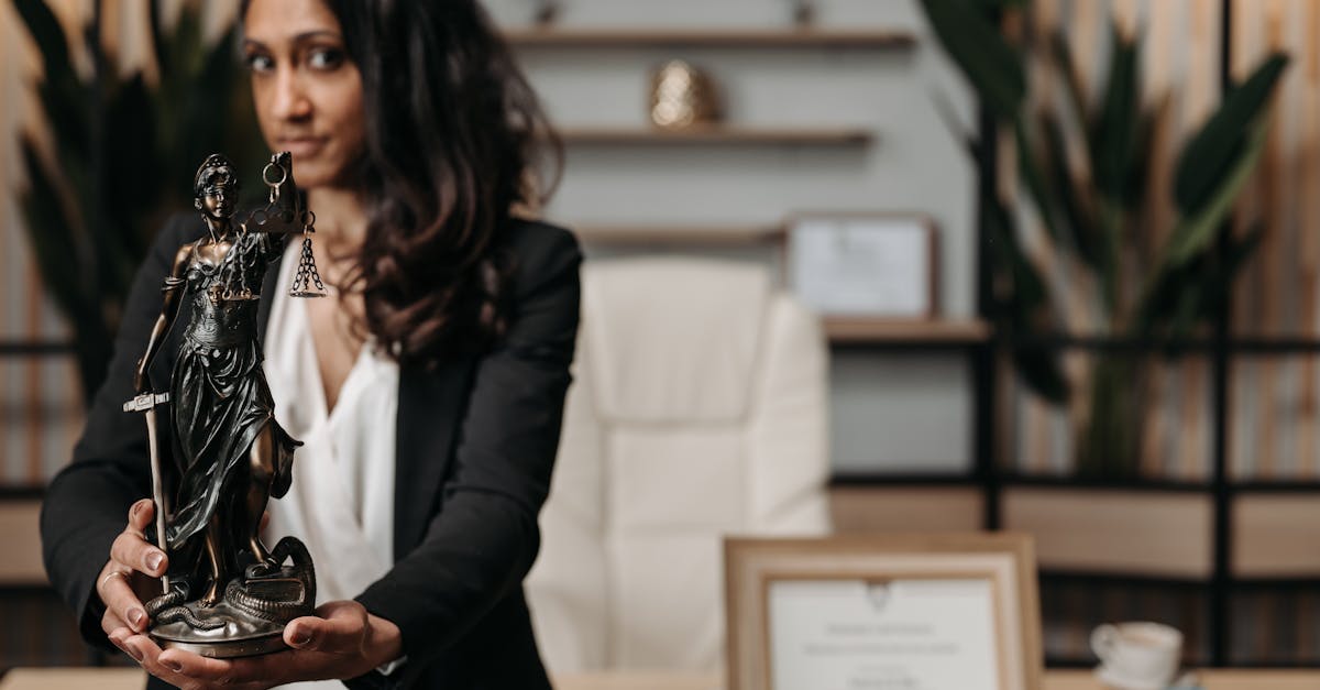 Mulher segurando estátua da deusa Têmis em um escritório de advocacia moderno. — Foto: Pavel Danilyuk
