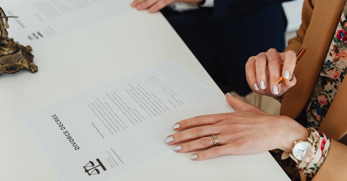 Mãos de uma mulher sobre um documento de decreto de divórcio em uma mesa branca de escritório. — Foto: www.kaboompics.com