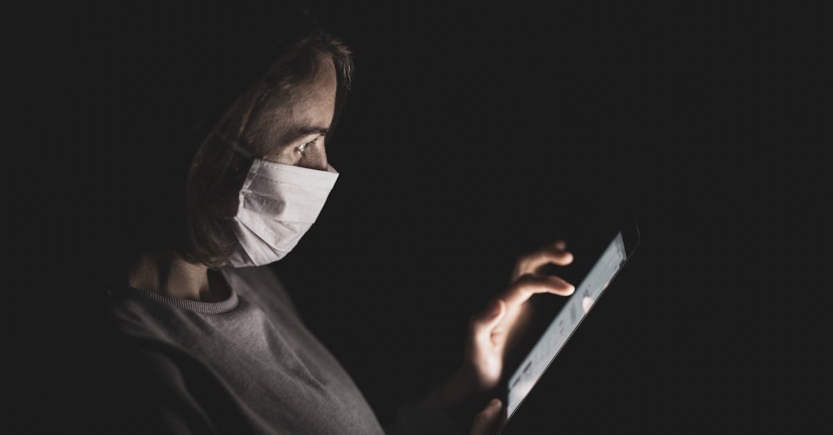 Eca digital novas regras para proteger criancas na internet 79498 1772881335 Pessoa usando máscara de proteção facial manuseando um tablet no escuro, com a tela iluminando seu rosto. — foto: engin akyurt