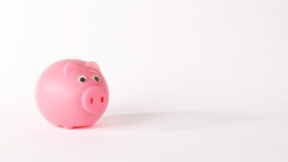Um cofrinho de porco rosa em um fundo branco limpo, simbolizando economia e reserva financeira. — Foto: Ann H