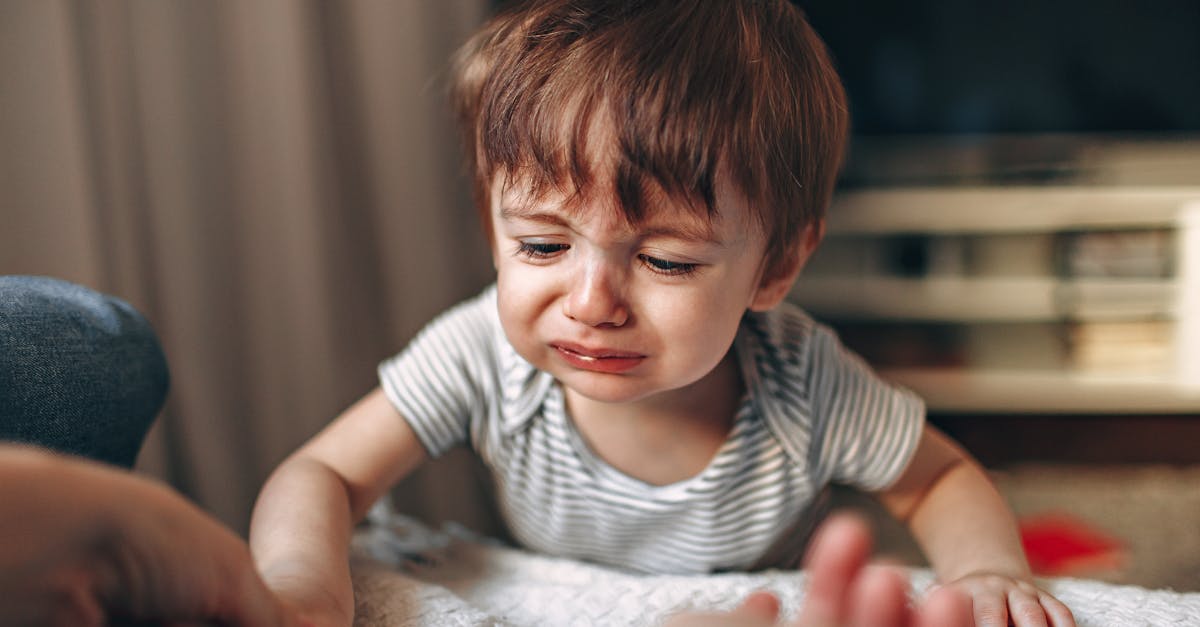 Criança pequena com expressão de choro e tristeza em um ambiente doméstico. — Foto: Helena Lopes