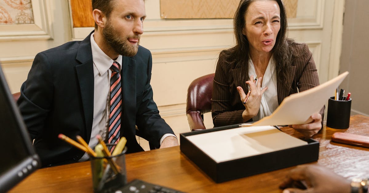 Dois advogados em trajes formais discutindo documentos sobre uma mesa de madeira em um escritório clássico. — Foto: RDNE Stock project