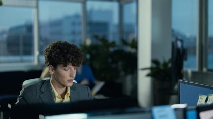 Jovem profissional de terno trabalhando em um escritório moderno em frente ao computador durante o entardecer. — Foto: cottonbro studio
