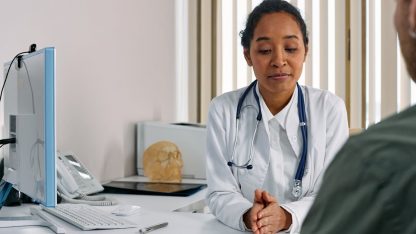 Médica de jaleco branco e estetoscópio conversando seriamente com um paciente em seu consultório. — Foto: cottonbro studio
