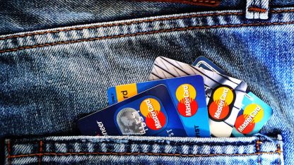 Diversos cartões de crédito coloridos saindo do bolso traseiro de uma calça jeans azul. — Foto: Pixabay