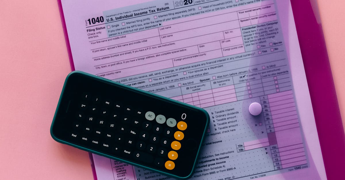 Formulário de declaração de imposto de renda sobre uma pasta rosa com um celular exibindo uma calculadora. — Foto: Nataliya Vaitkevich