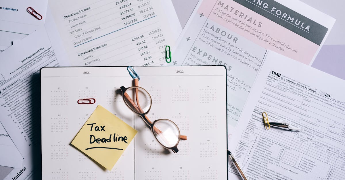 Documentos fiscais, óculos e agenda com lembrete escrito 'Tax Deadline' sobre uma mesa. — Foto: Leeloo The First