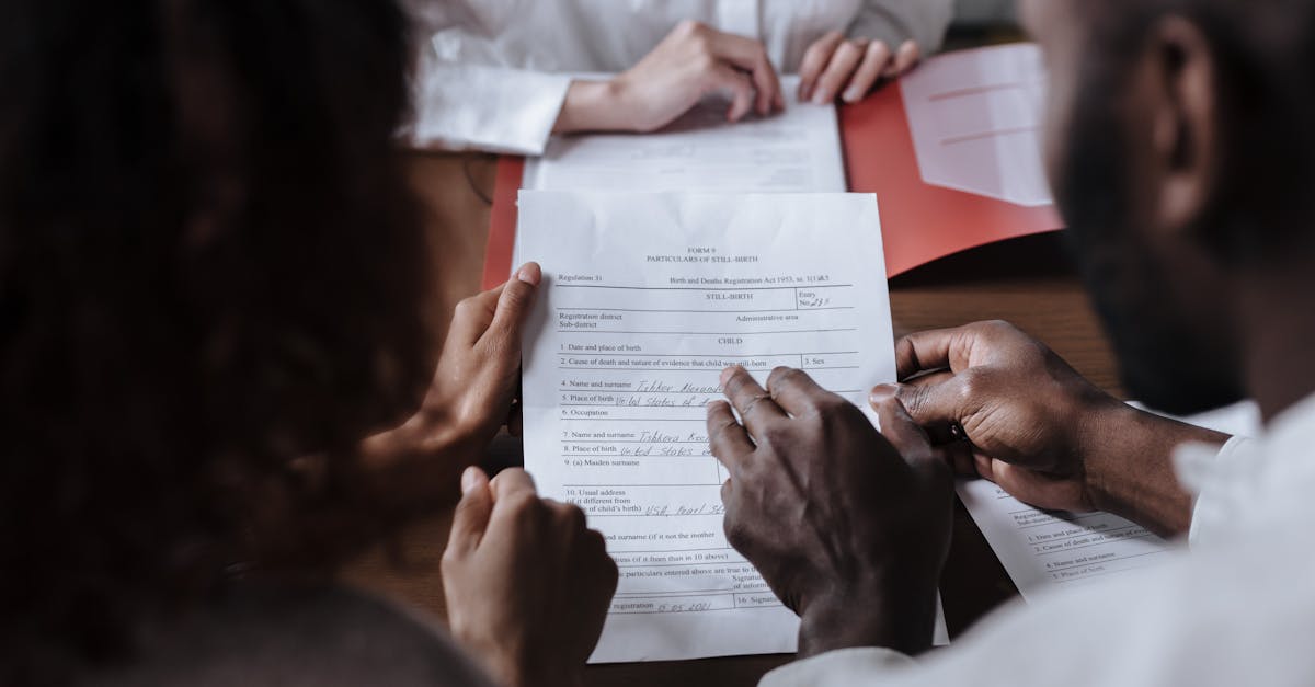Uniao estavel 82263 1774987381 Pessoas em uma reunião analisando e segurando um documento jurídico sobre uma mesa de madeira. — foto: ron lach