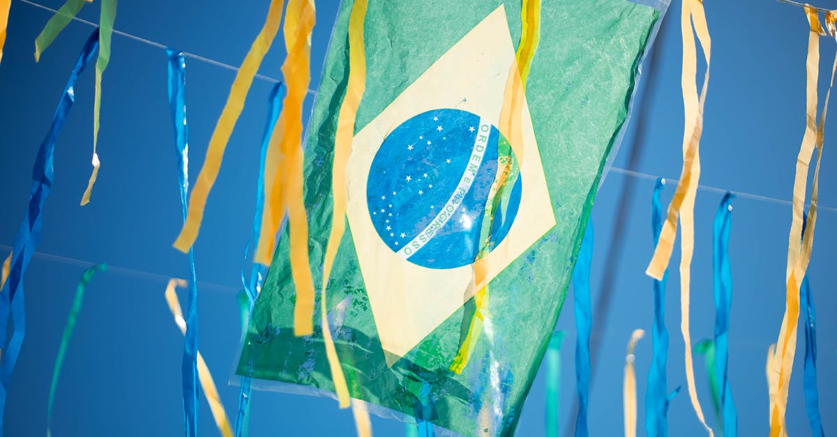 Bandeira do Brasil pendurada com fitas coloridas amarelas e azuis sob um céu limpo. — Foto: Wallace Chuck