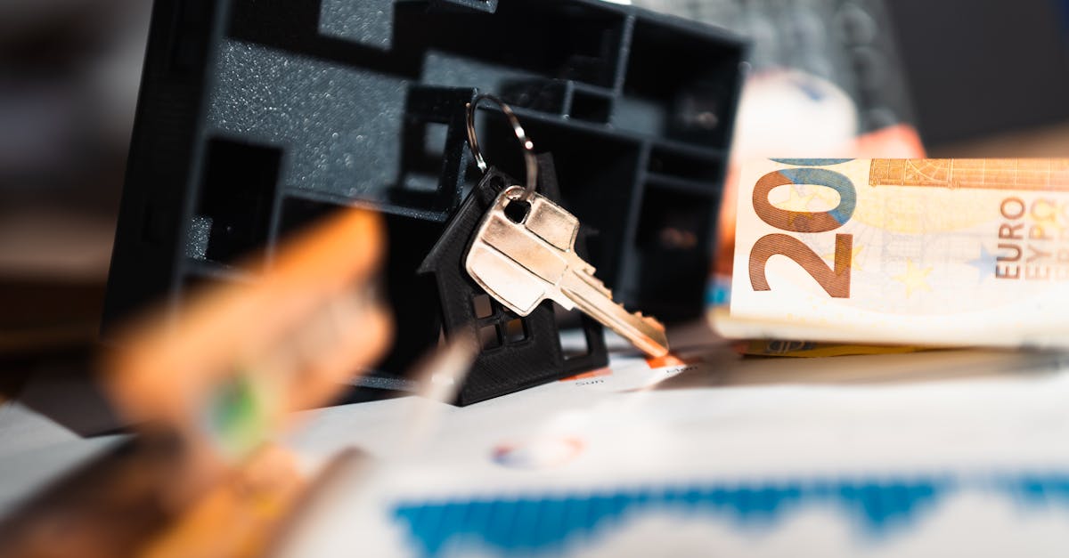 Chave de casa sobre documentos financeiros ao lado de uma nota de 200 euros e maquete de imóvel. — Foto: Jakub Zerdzicki