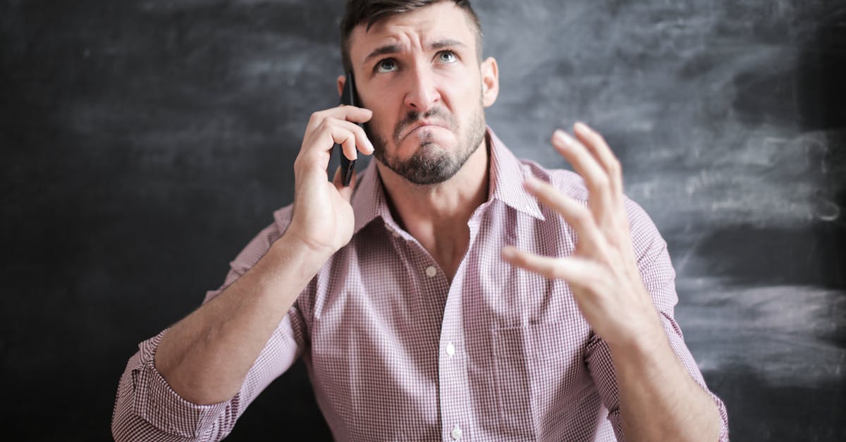 Homem com expressão de frustração e indignação ao falar no celular, representando conflito com operadora. — Foto: Andrea Piacquadio