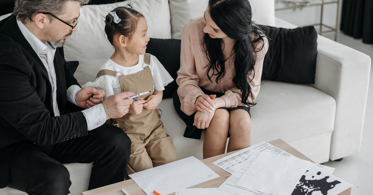 Advogado em terno conversa com mulher e criança sentados em um sofá com documentos sobre a mesa. — Foto: Pavel Danilyuk