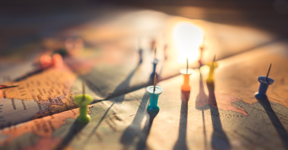 Mapa mundi com alfinetes coloridos marcando diferentes localizações sob luz solar suave. — Foto: Aksonsat Uanthoeng