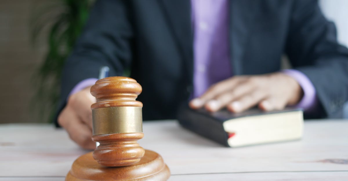 Juiz com a mão sobre um livro jurídico ao lado de um martelo de madeira em uma mesa. — Foto: Towfiqu barbhuiya