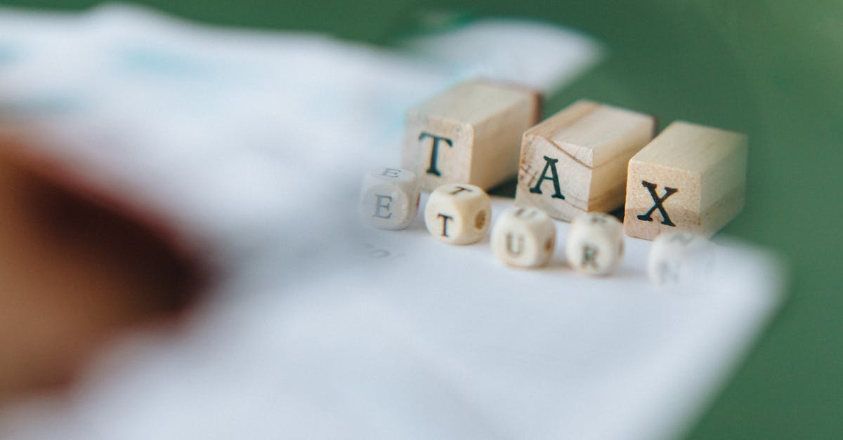 Blocos de madeira formando a palavra TAX sobre documentos financeiros em uma mesa. — Foto: Nataliya Vaitkevich