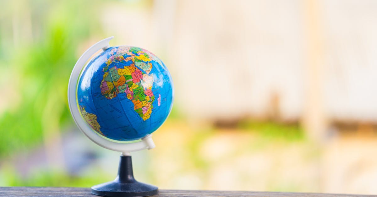 Um pequeno globo terrestre colorido sobre uma superfície de madeira com fundo claro e desfocado. — Foto: Nothing Ahead