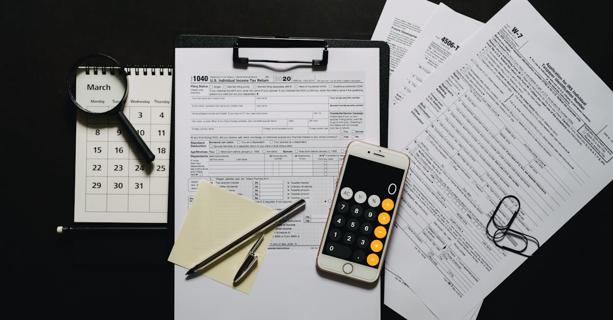 Documentos fiscais em uma prancheta ao lado de um celular com calculadora, lupa, caneta e calendário sobre mesa preta. — Foto: Leeloo The First