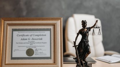 Estátua da deusa Têmis e certificado emoldurado sobre mesa de escritório de advocacia com cadeira ao fundo. — Foto: Pavel Danilyuk